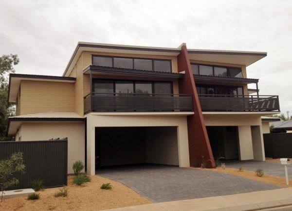 Two-story modern home with brown and beige exterior, balconies, and a carport.
