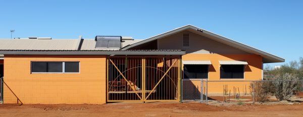 An orange building with a gate and a blue sky in the background.