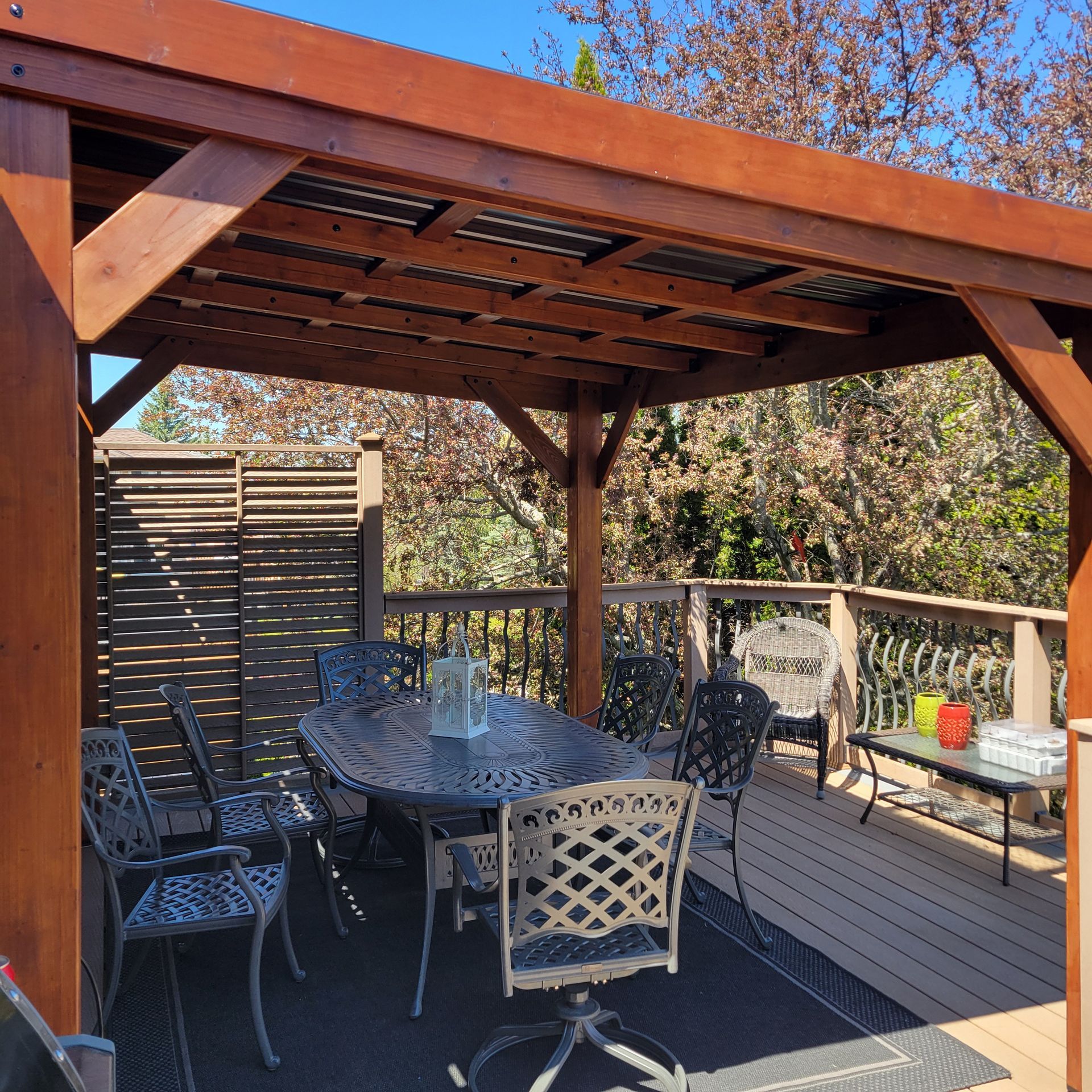 Patio with a wooden pergola, dining set, and privacy screen.