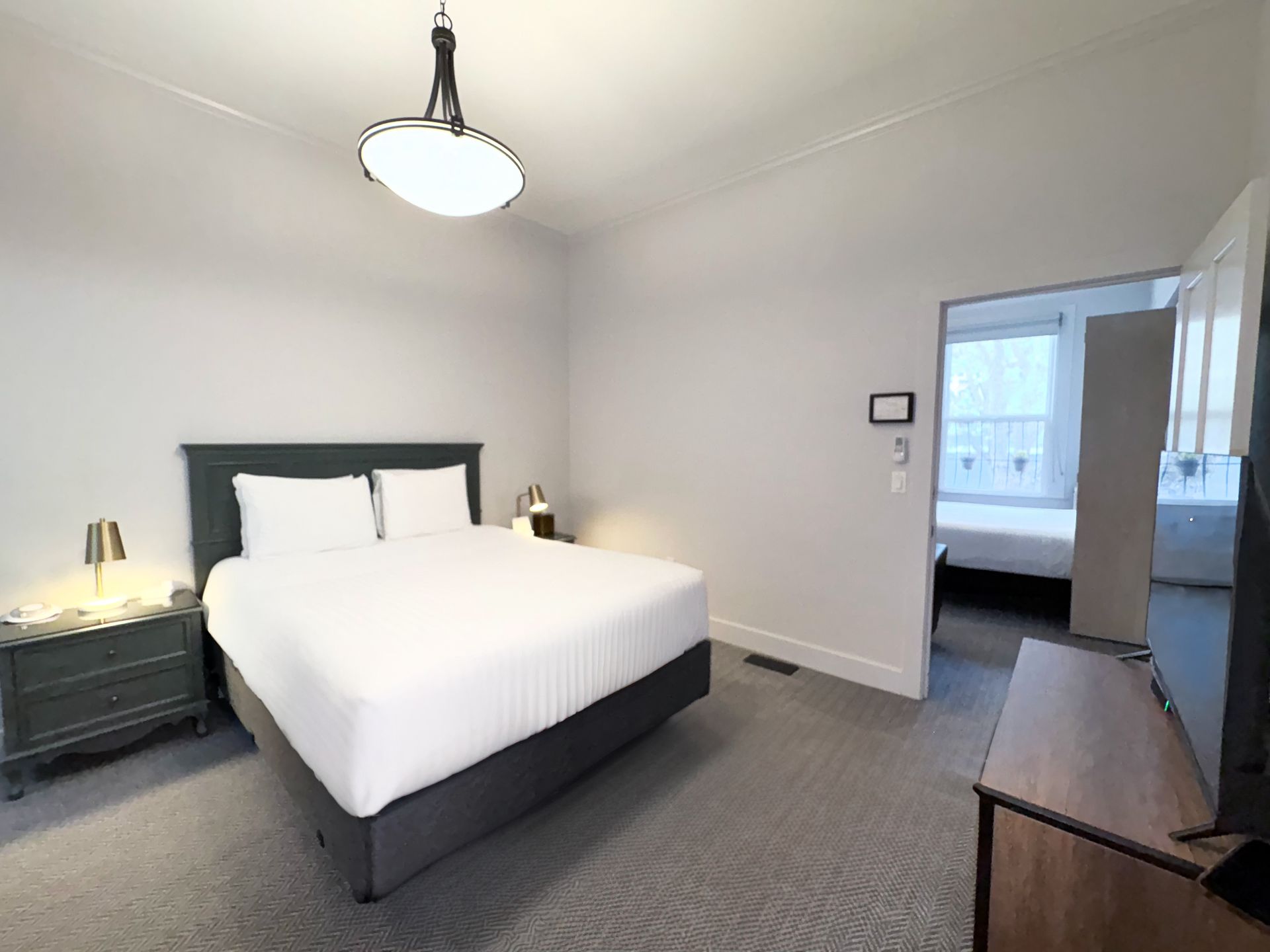 A hotel room with a king size bed and a flat screen tv.
