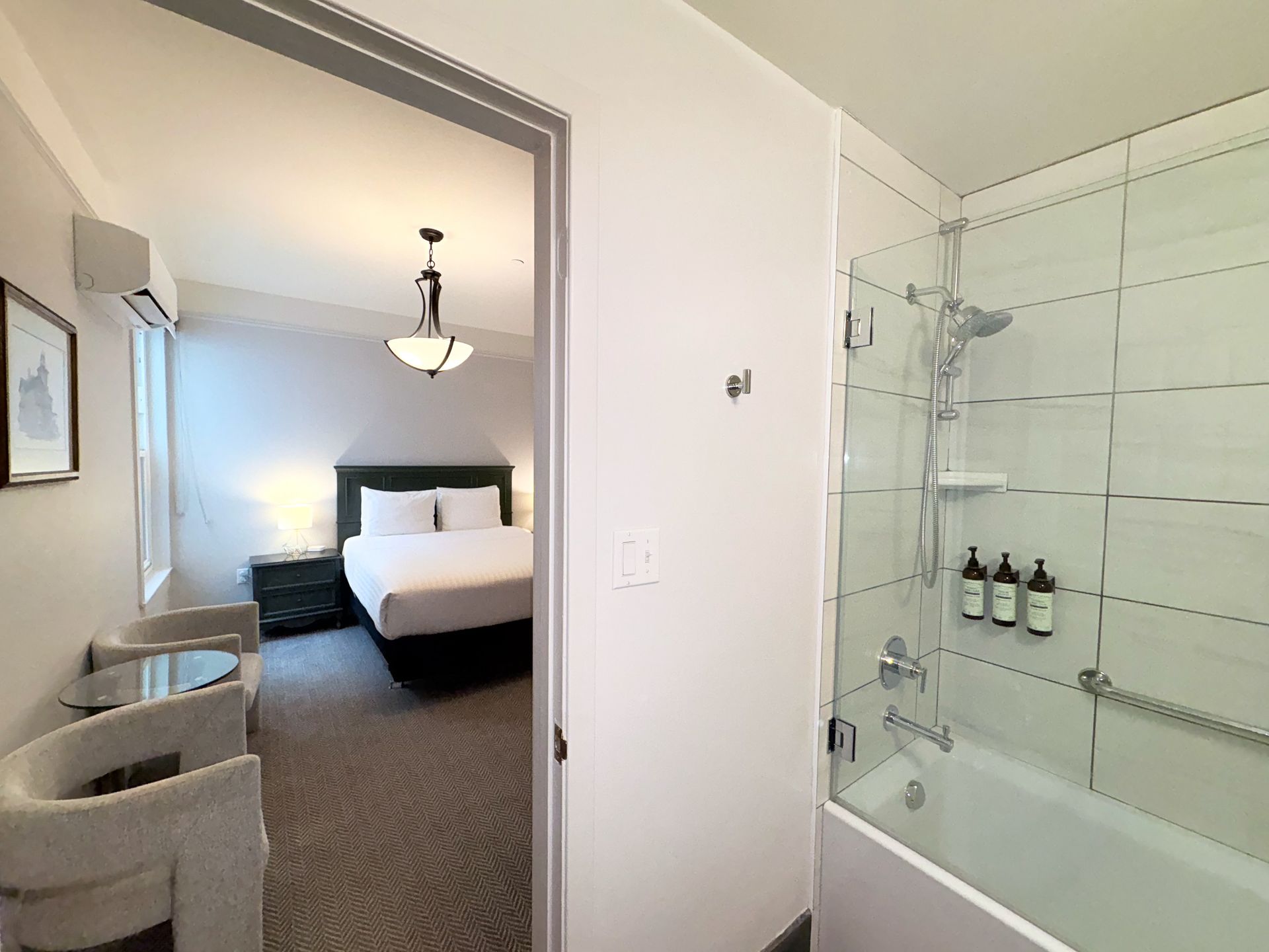 A hotel room with a king size bed and a bathtub.