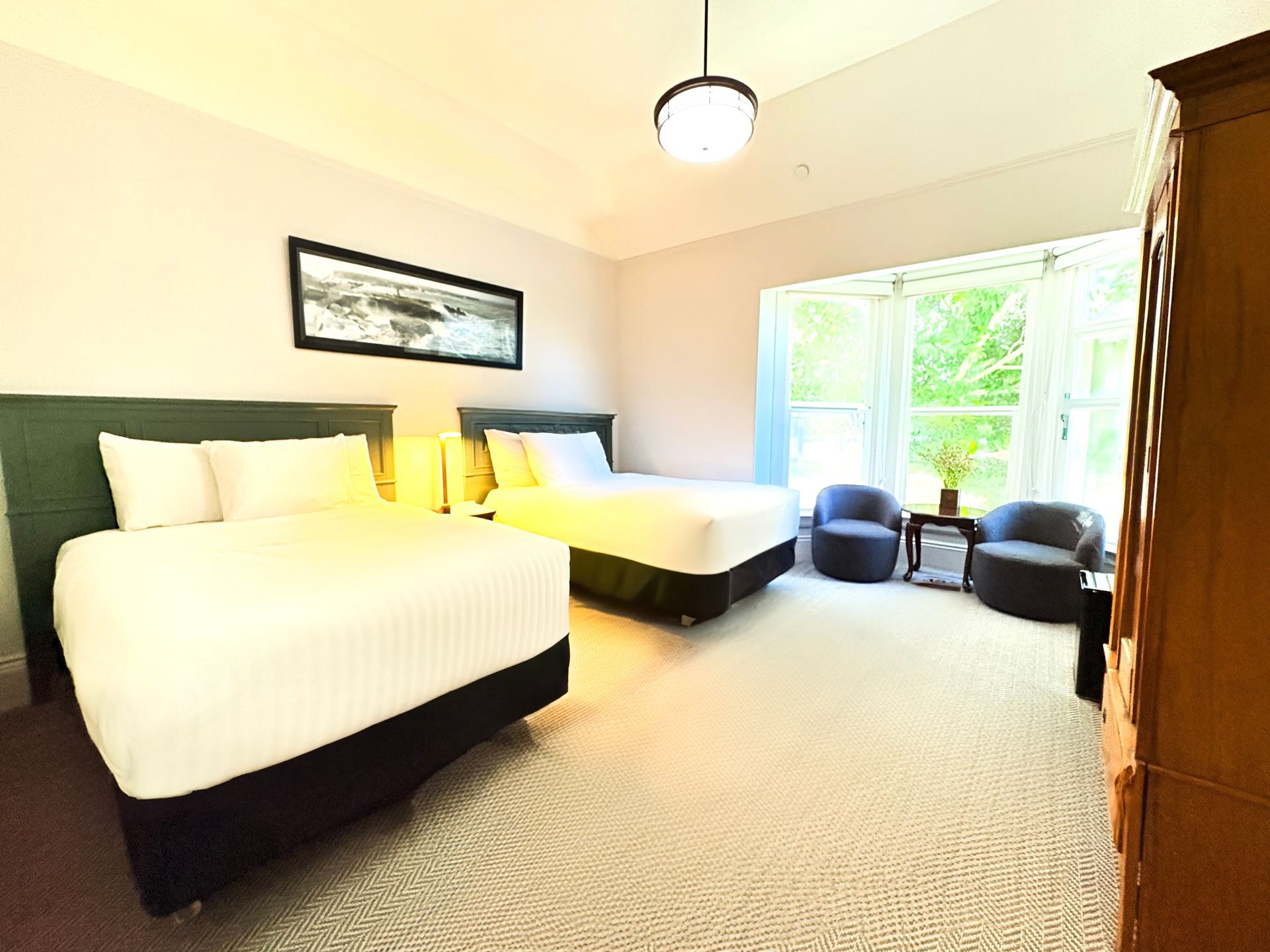 A hotel room with two beds and two chairs