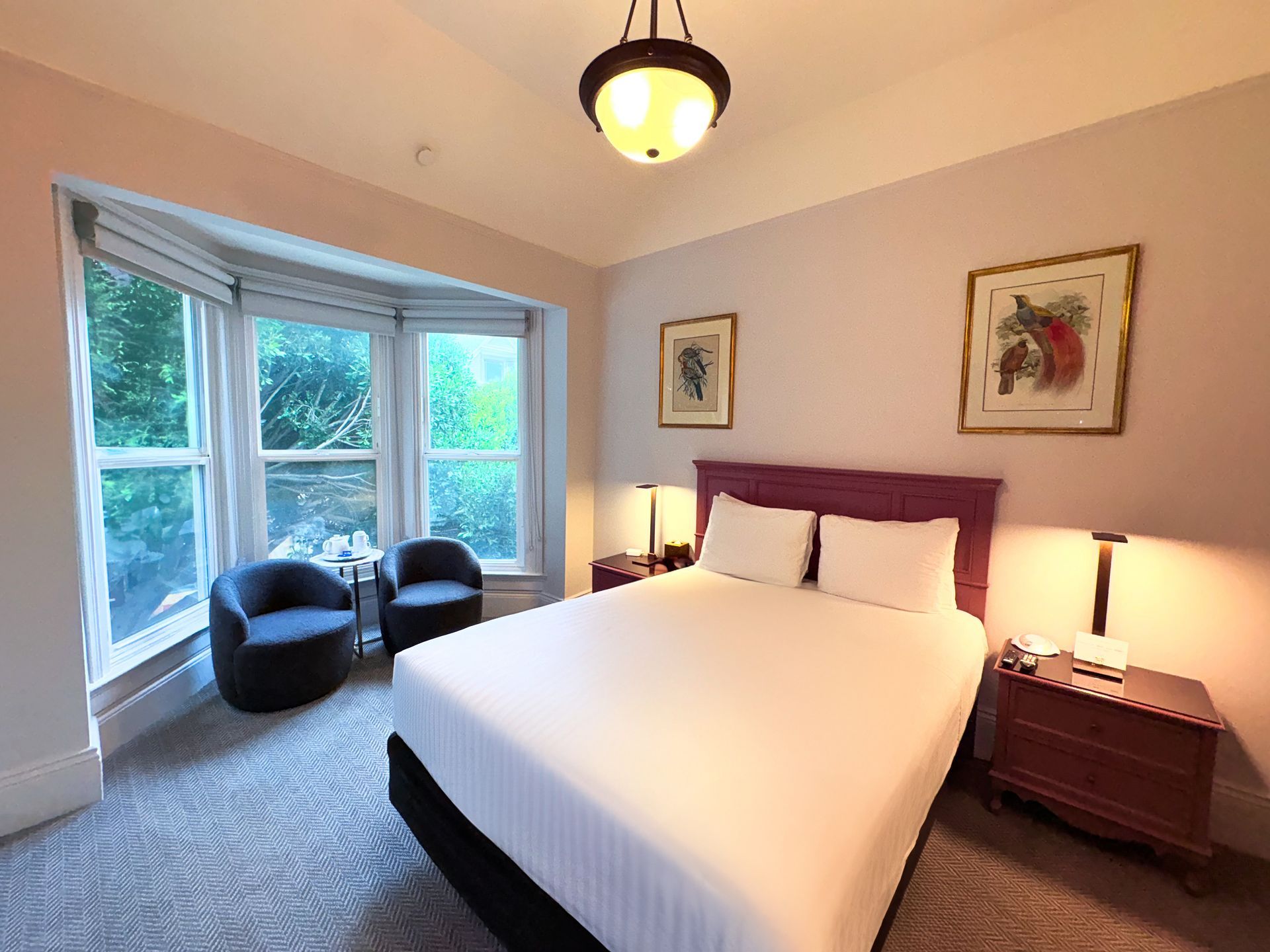 A hotel room with a king size bed and two chairs