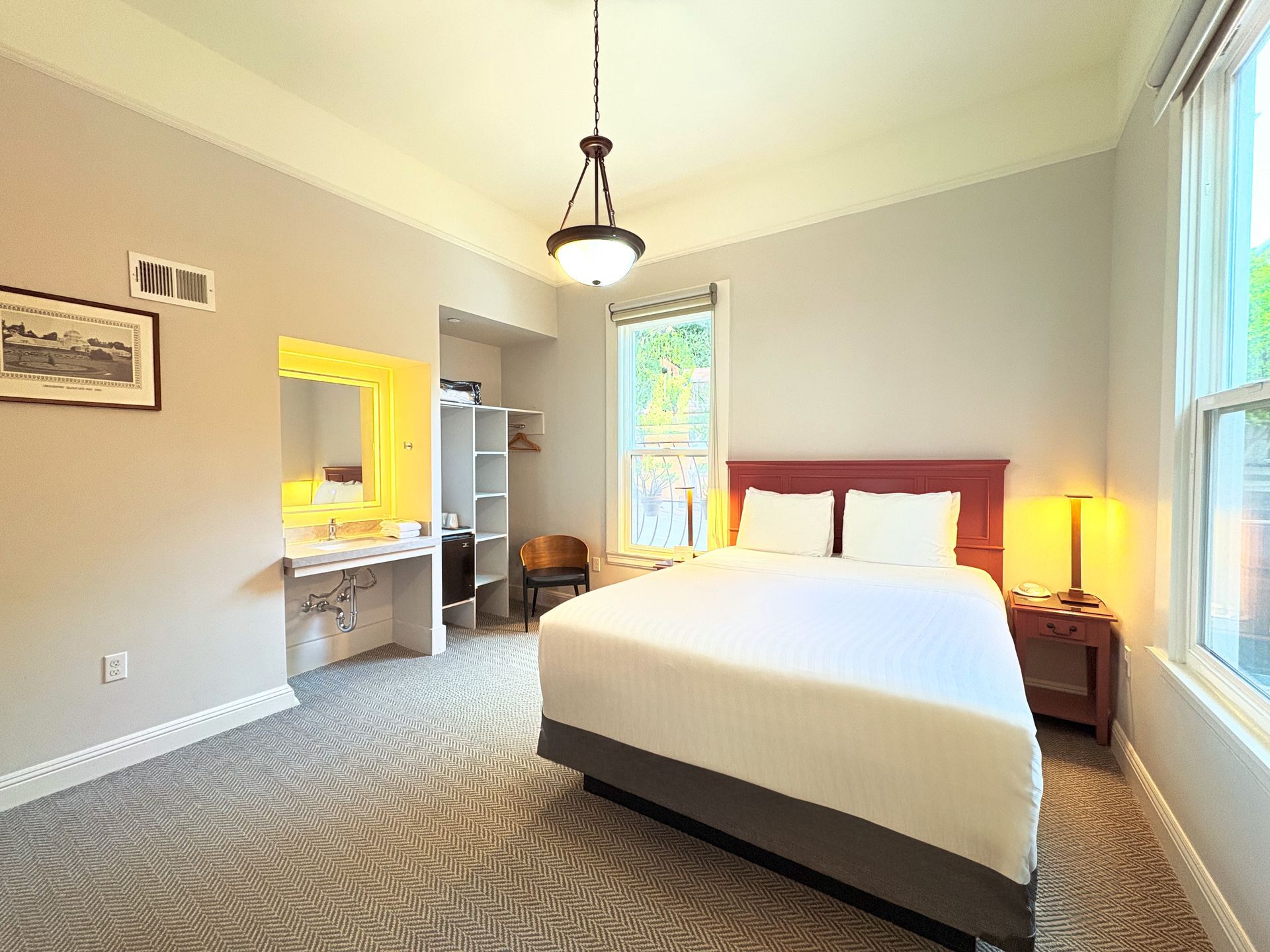 A hotel room with a king size bed and a sink.