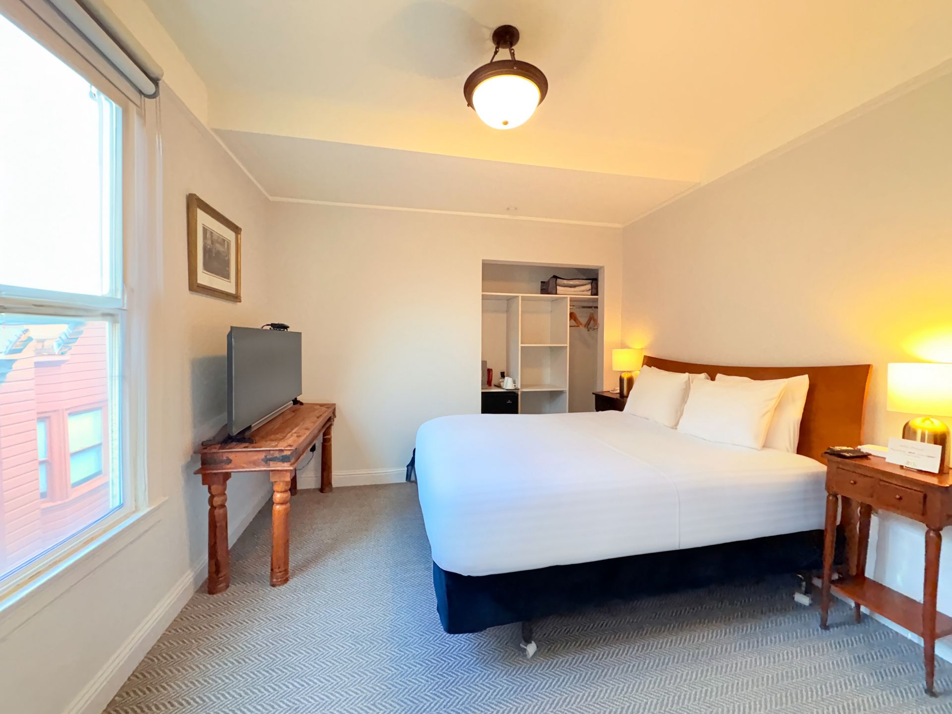 A hotel room with a king size bed and a flat screen tv