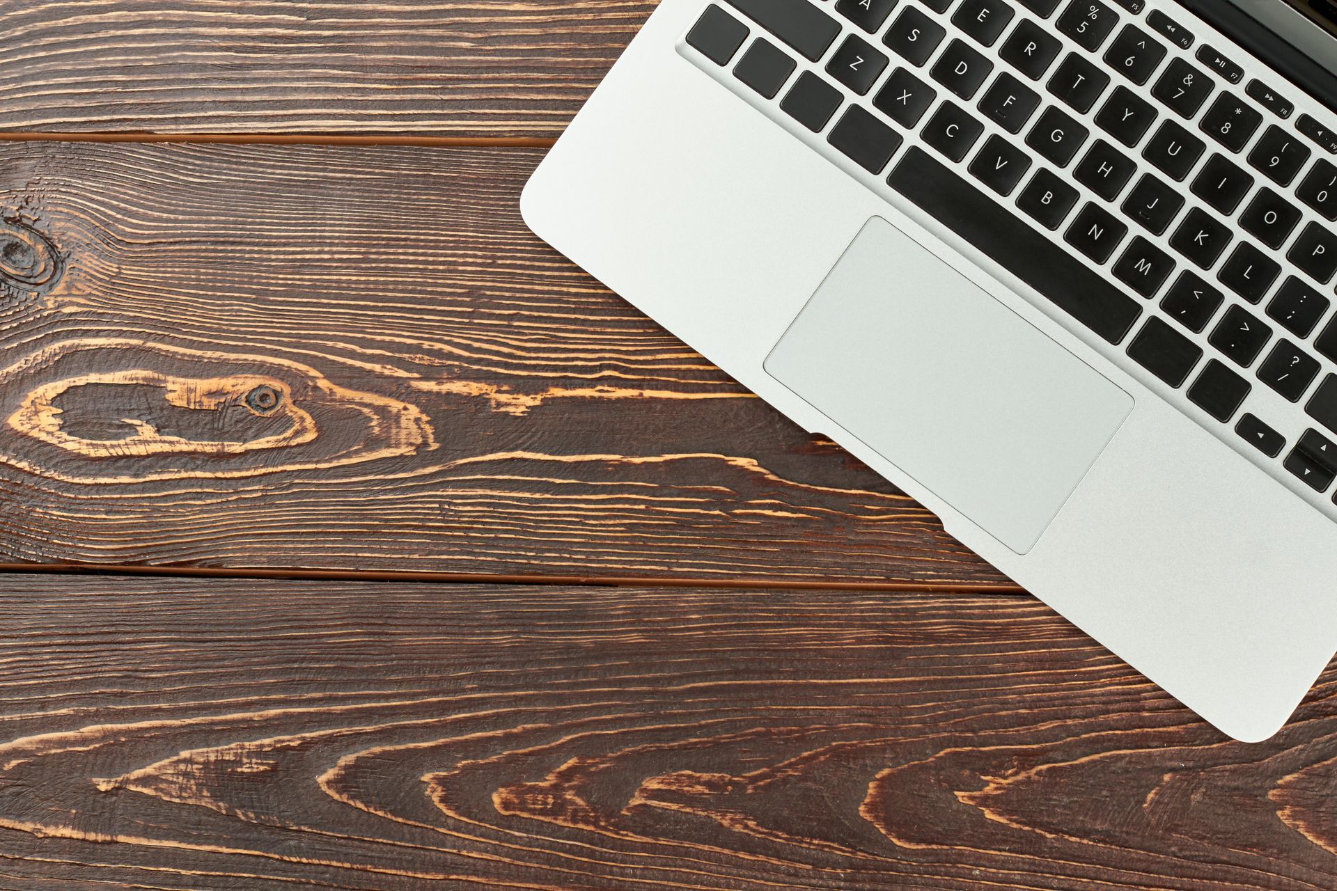 A laptop computer is sitting on a wooden table.