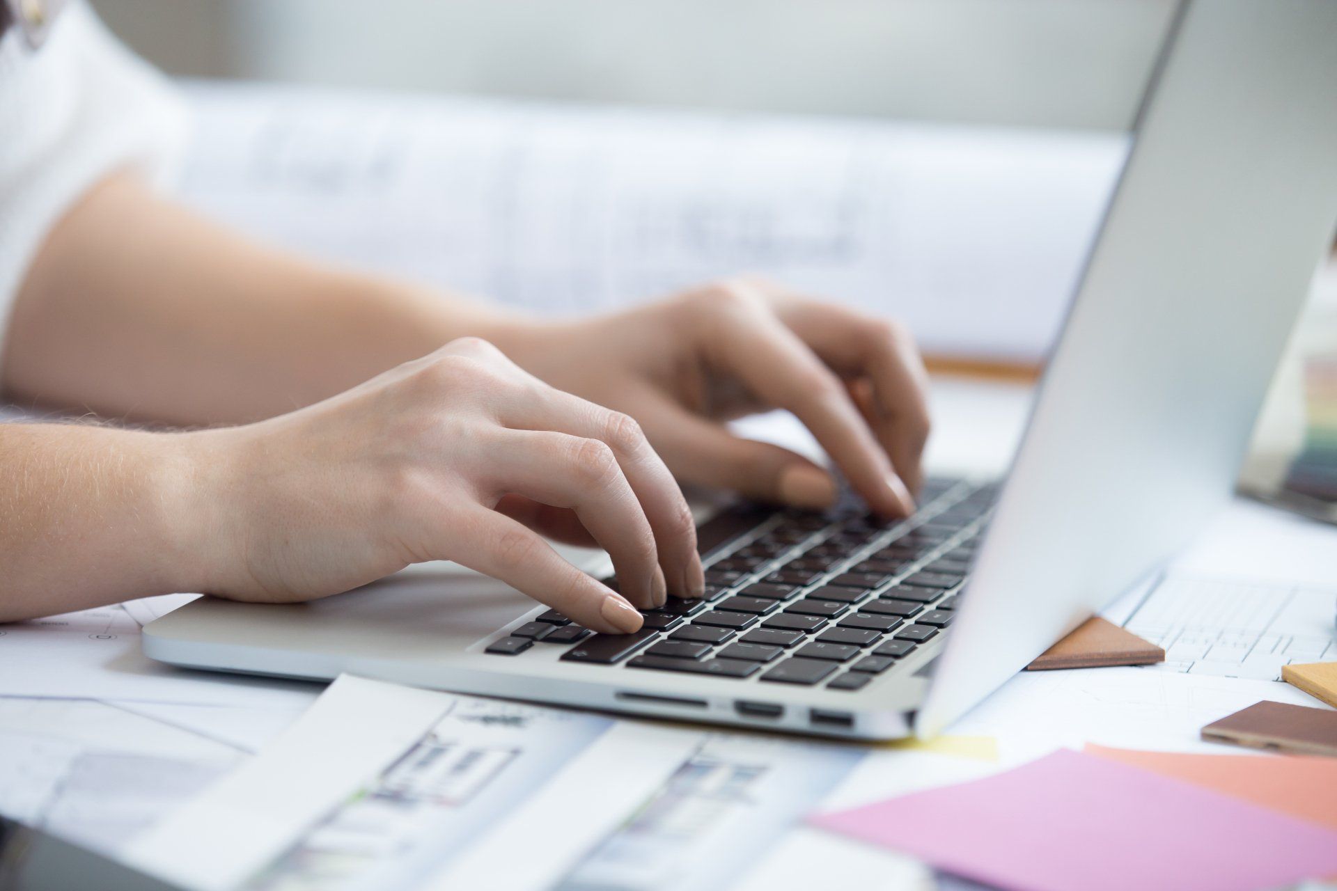 A person is typing on a laptop computer.