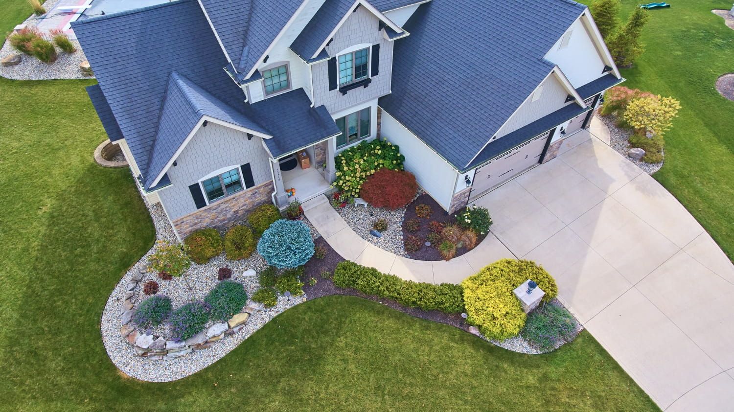 An aerial view of a large house with a blue roof