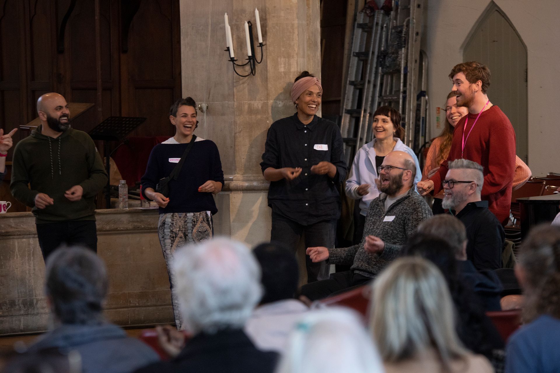 A group of people are standing in front of a crowd of people in a church.