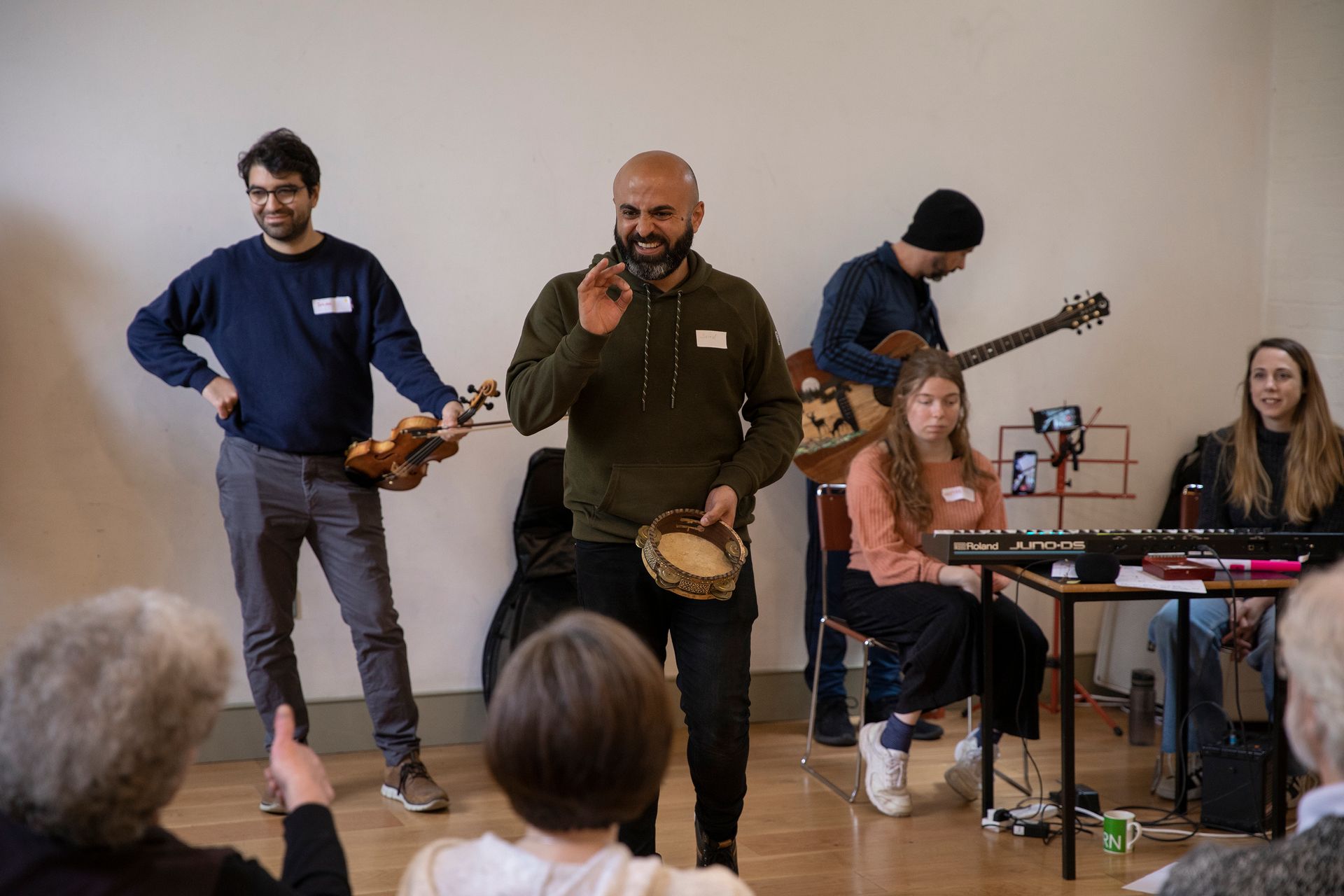 A group of people are playing instruments in a room.