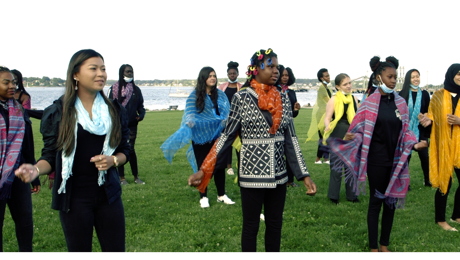 A group of women are dancing in a field.
