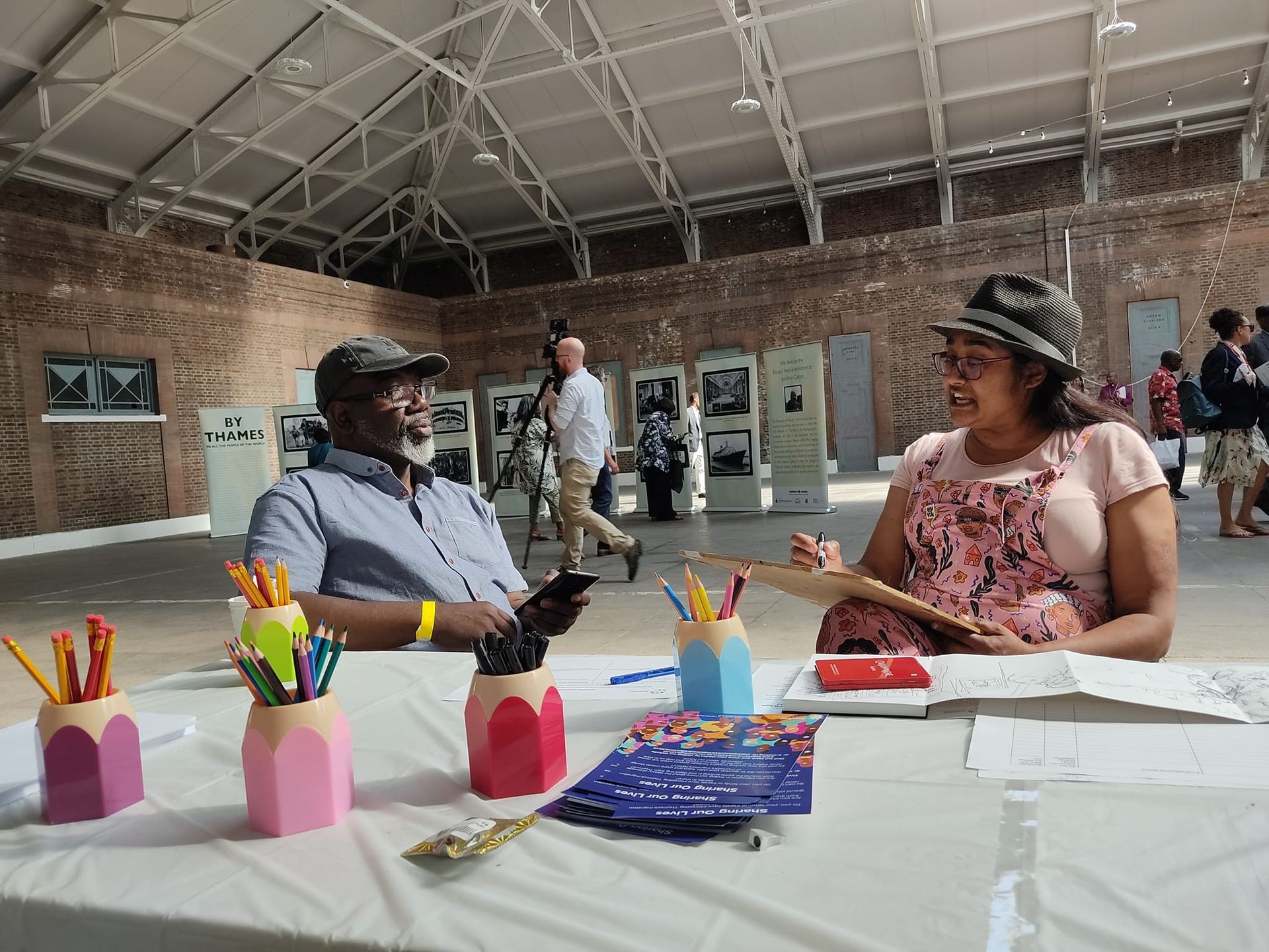 A man and a woman are sitting at a table in a room.