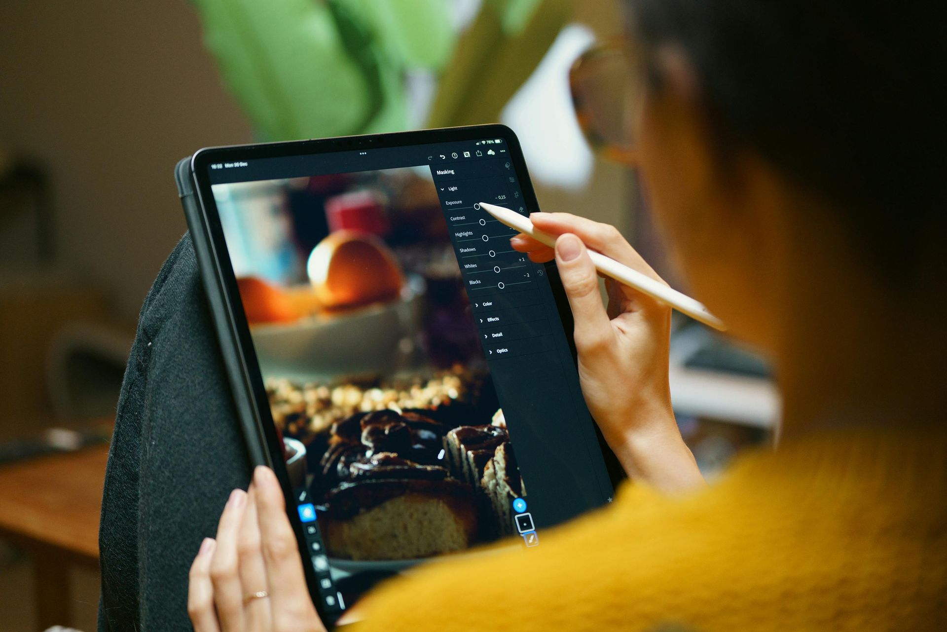 Person using a stylus on a tablet with a colorful digital artwork on screen