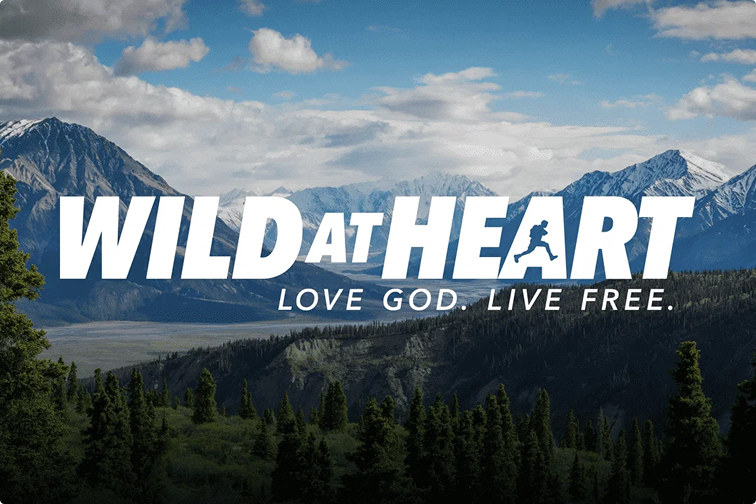 Mountain landscape with bold “WILD AT HEART” text and slogan “LOVE GOD. LIVE FREE.”
