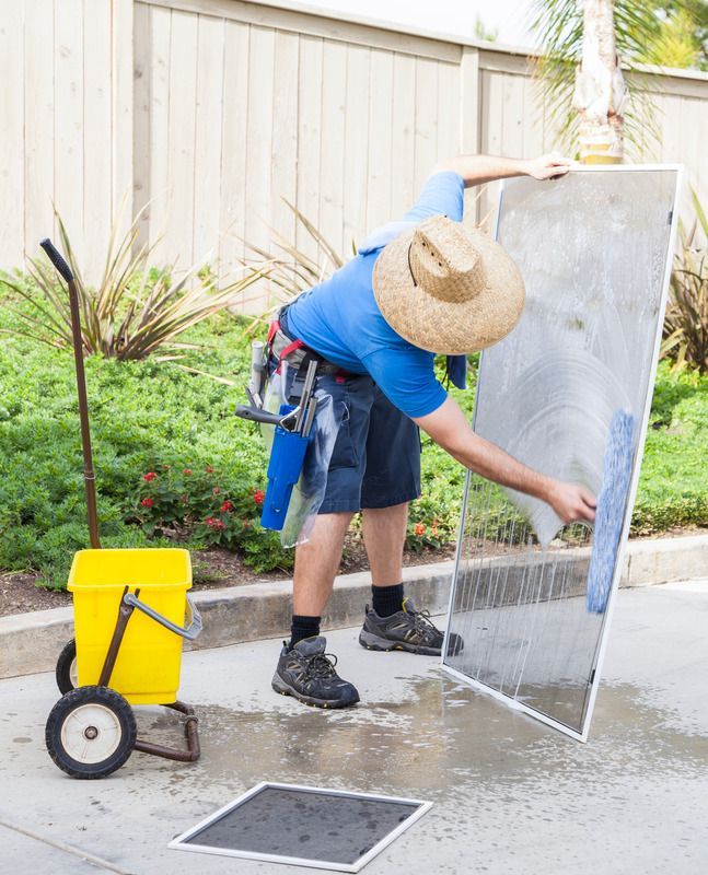 Man cleaning a window screen