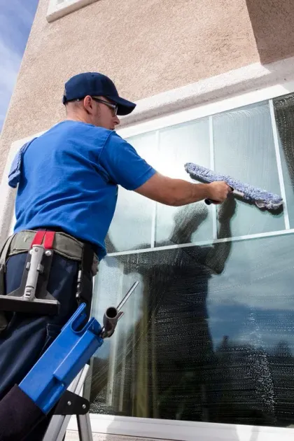 Man cleaning outside home window