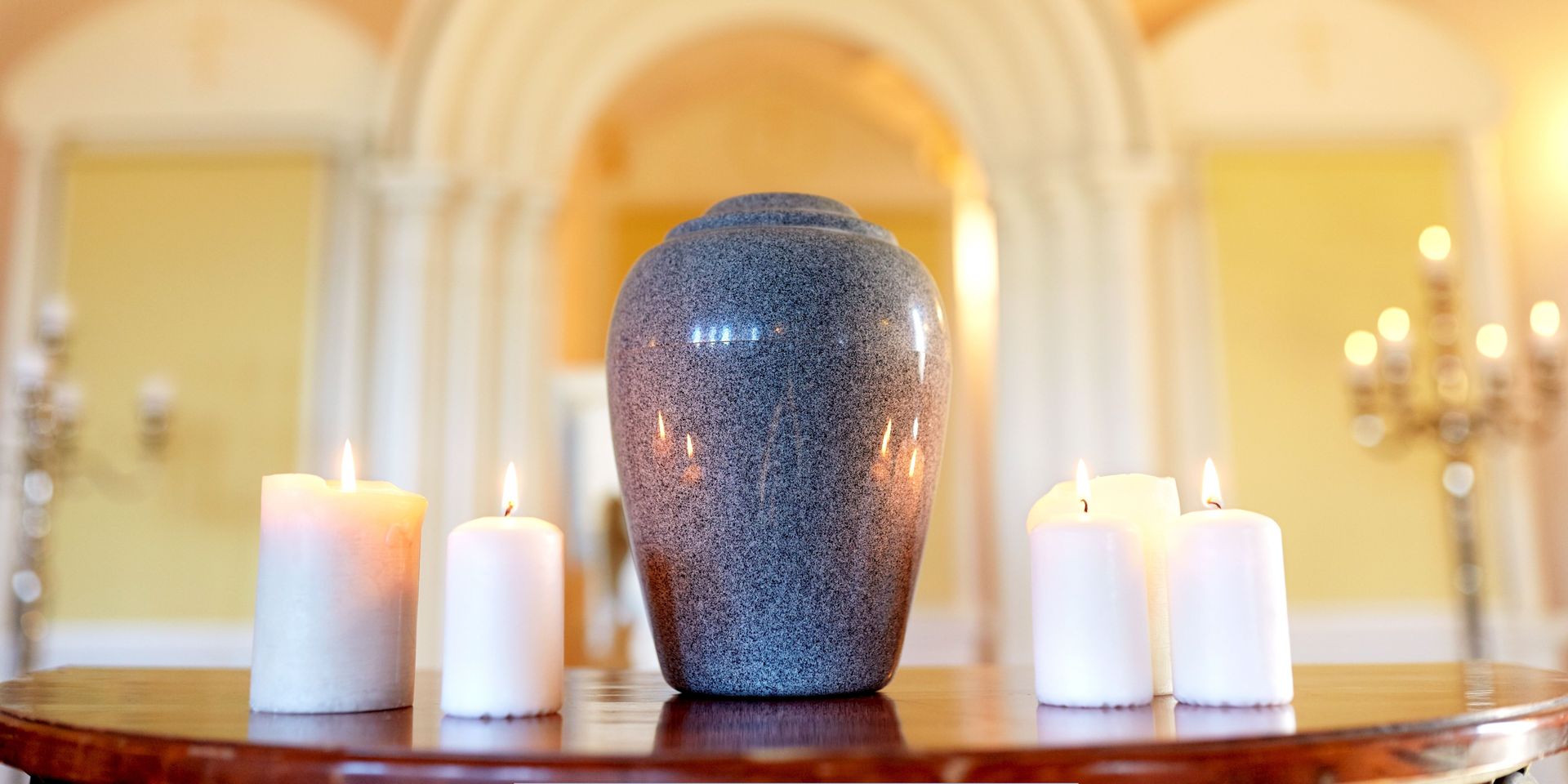 Elegant urn displayed with lit candles during a memorial service representing Cremation Services in Maple Shade, NJ.