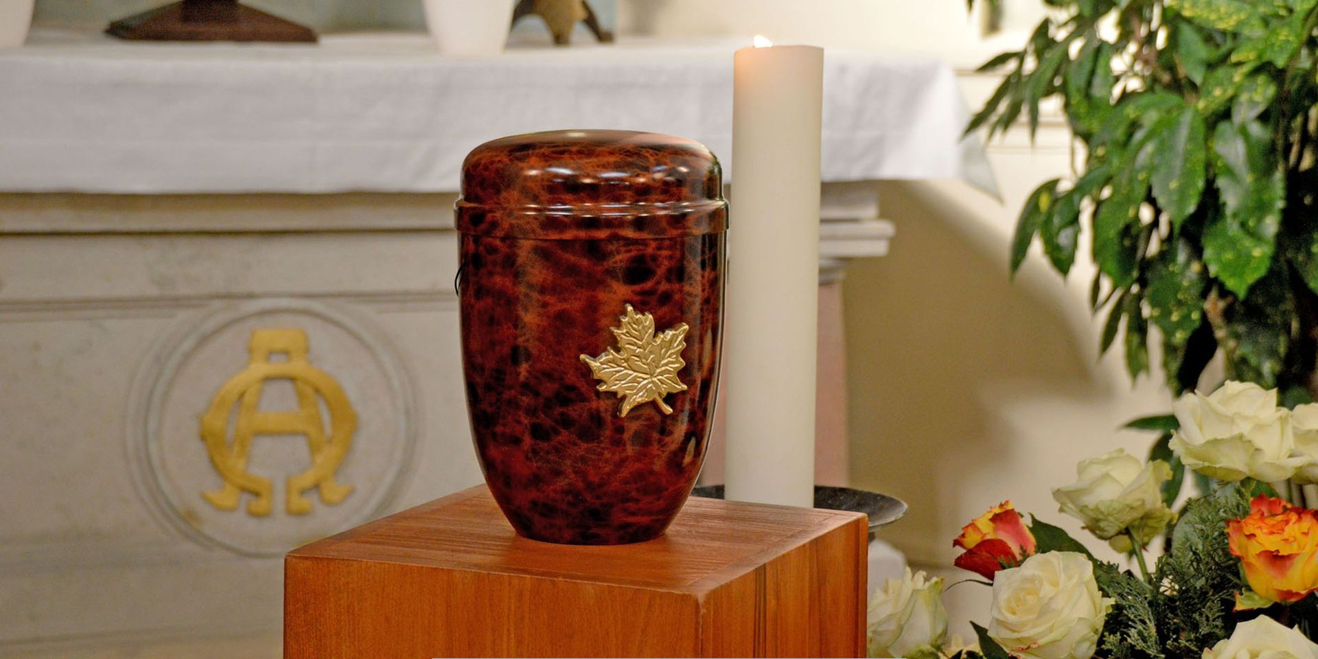 Red marble cremation urn displayed on a wooden pedestal during a service for Cremation Services in Pennsauken Township, NJ.