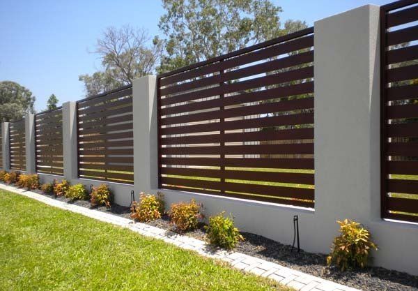 Brown horizontal slat fence with concrete pillars and small shrubs — Precision Patios Toowoomba In Toowoomba, QLD