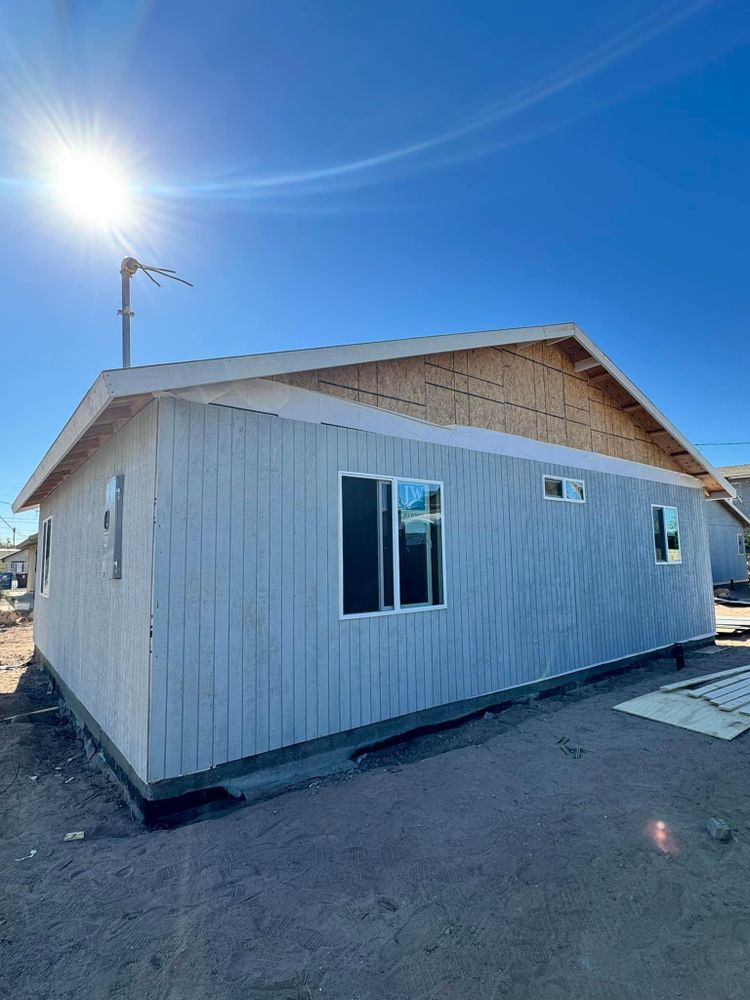 A small white house with a lot of windows is being built.