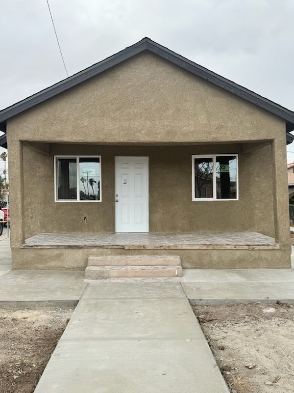A small house with a concrete walkway leading to it