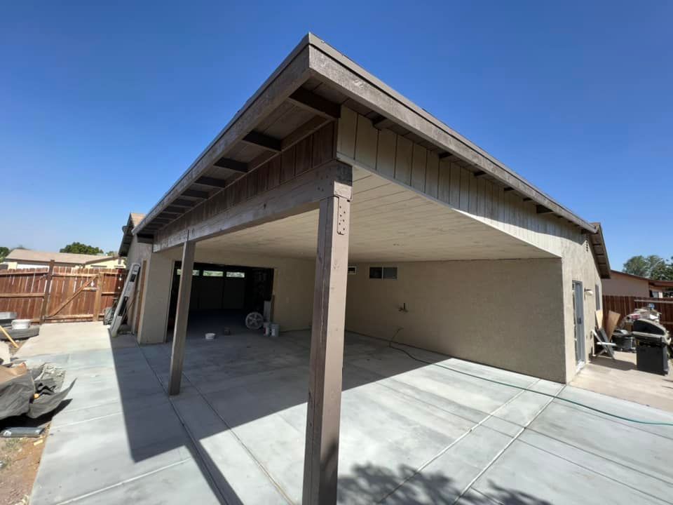 A carport is being built in the backyard of a house.