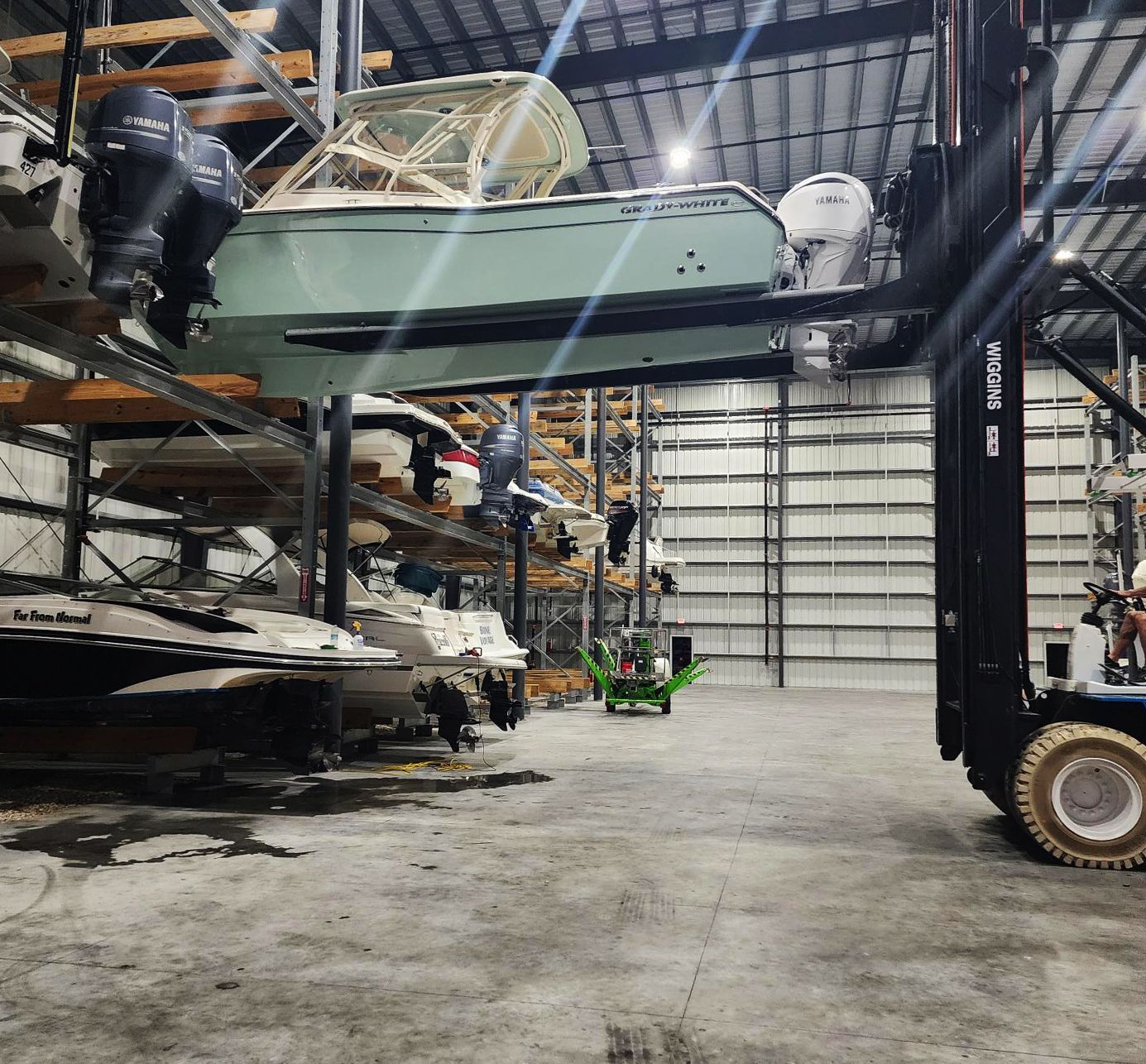 A forklift is lifting a boat in Riverview Marina boat storage building