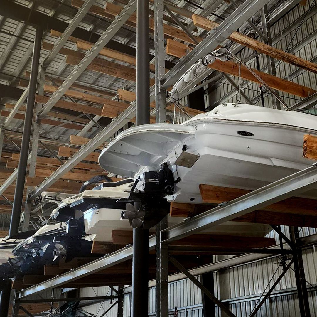A bunch of boats are stacked on top of each other in a warehouse at Riverview Marina