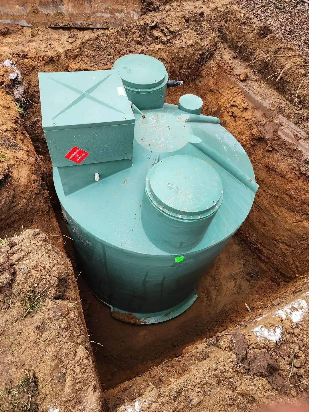 Green septic tank in an excavated dirt pit, ready for burial. — Mi Plumber Wagga Wagga in Cootamundra, NSW