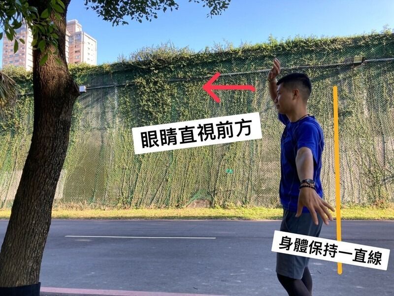 A man is standing next to a tree on the side of the road.