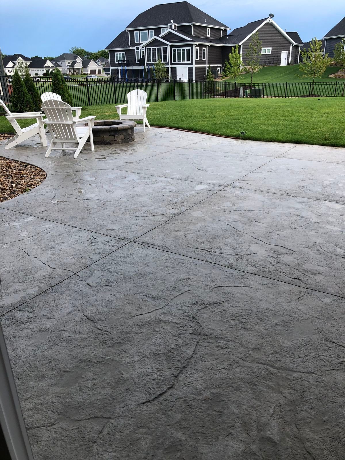 Covered patio with dining set, grill, and planters.
