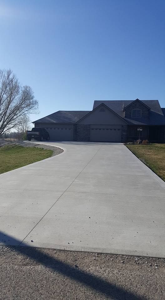 New two-story house under construction with a concrete driveway and an open garage door.