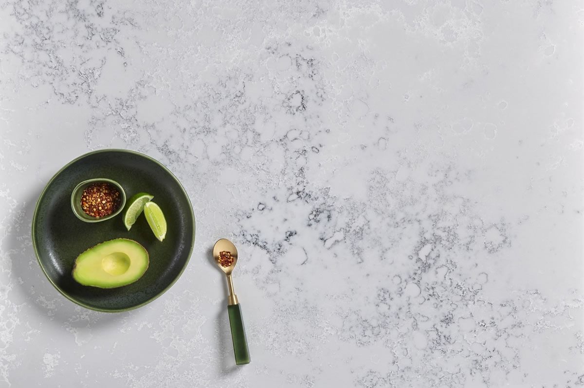 Avocado toast and a small bowl of salsa on a gray table, with a spoon nearby