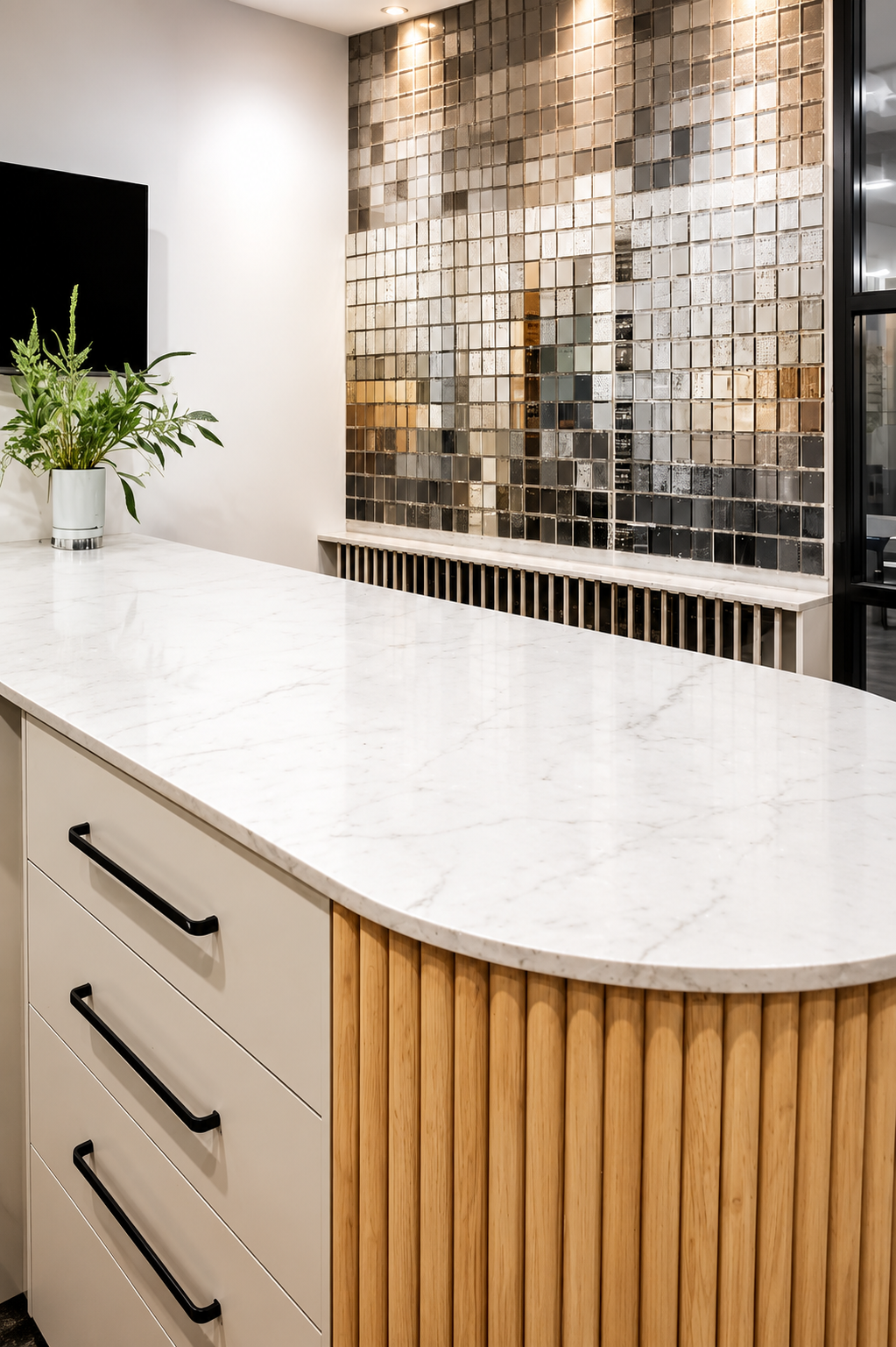 Modern kitchen island with white marble countertop, fluted wood base, and mirrored tile backsplash