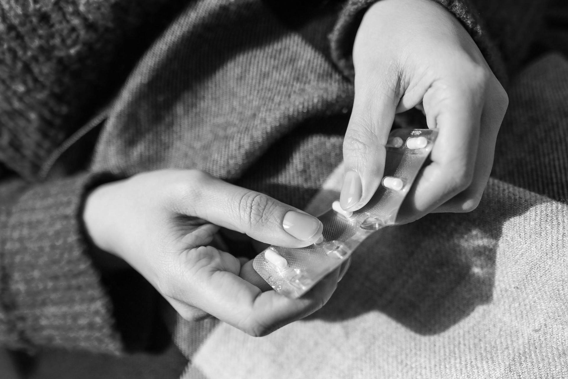 A person holding a blister pack of pills for Gesond's medication and prescription management service.
