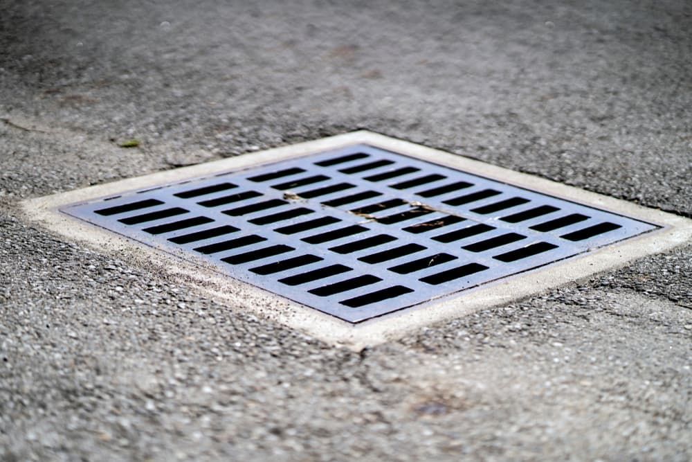 A Manhole Cover on The Side of A Road — Origin Plumbing & Gas in Tuckurimba, NSW