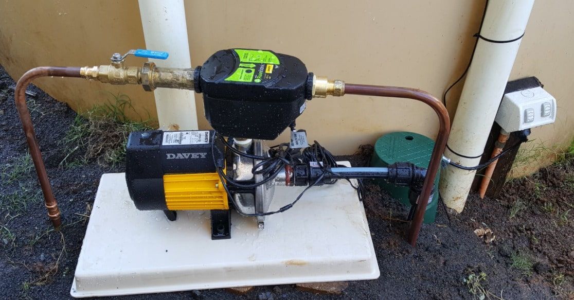 A Water Pump Is Sitting on Top of A Concrete Platform — Origin Plumbing & Gas in Tuckurimba, NSW