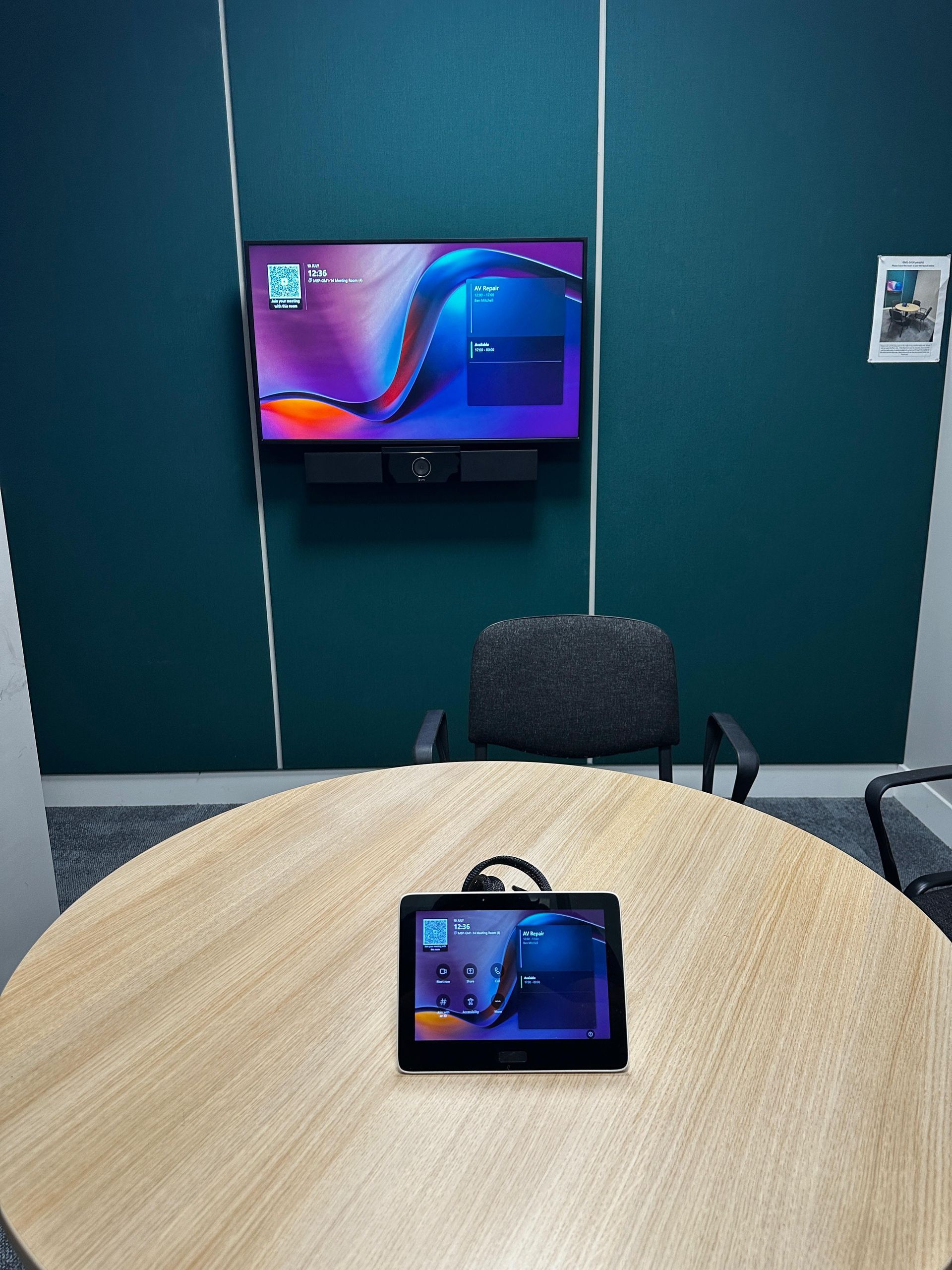 Meeting room with a wall-mounted display and tabletop room control panel