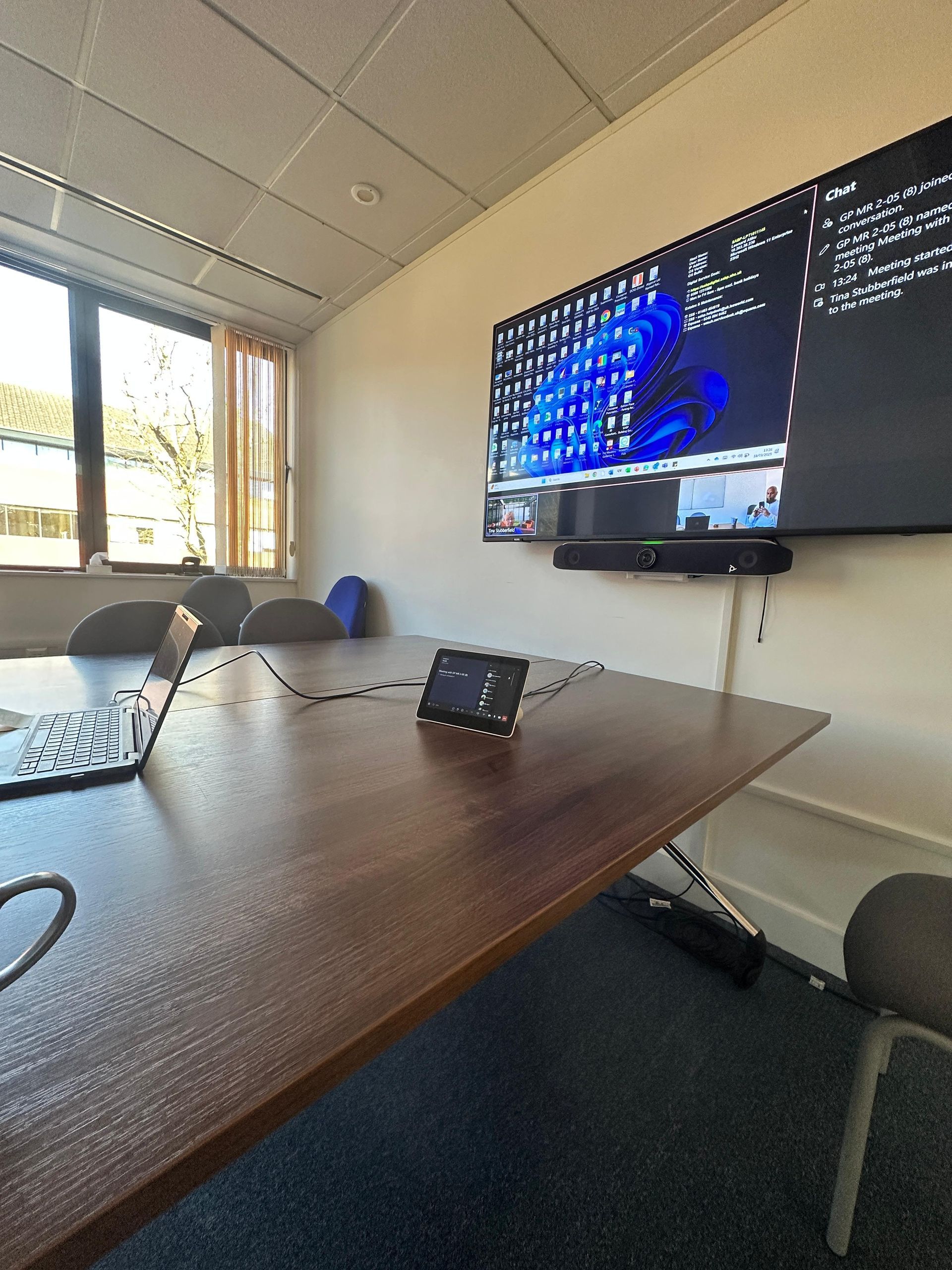 Meeting room with a video conferencing display and tabletop control panel