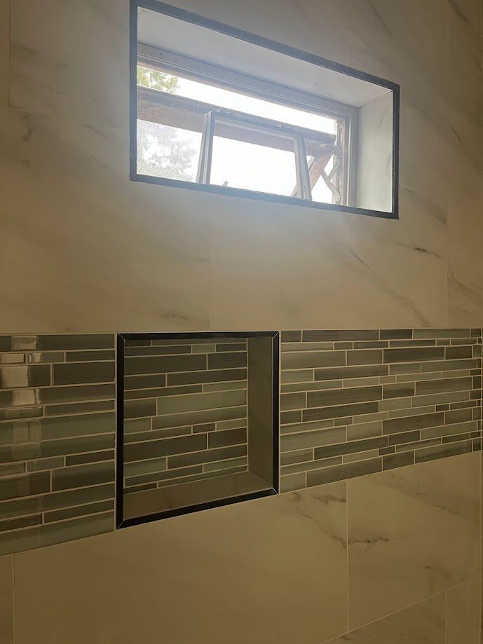 A bathroom with a window and a niche in the wall.
