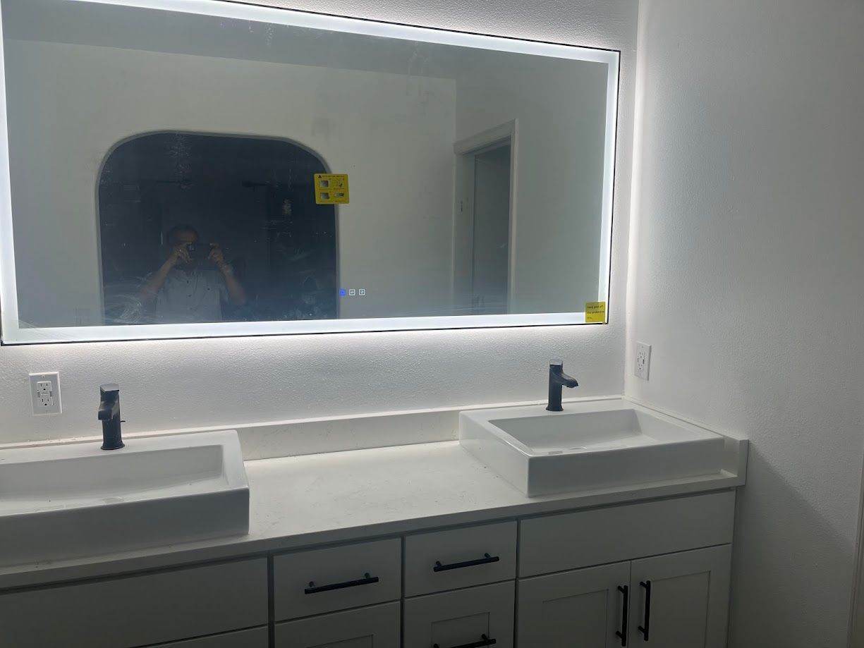 A bathroom with two sinks and a large mirror.