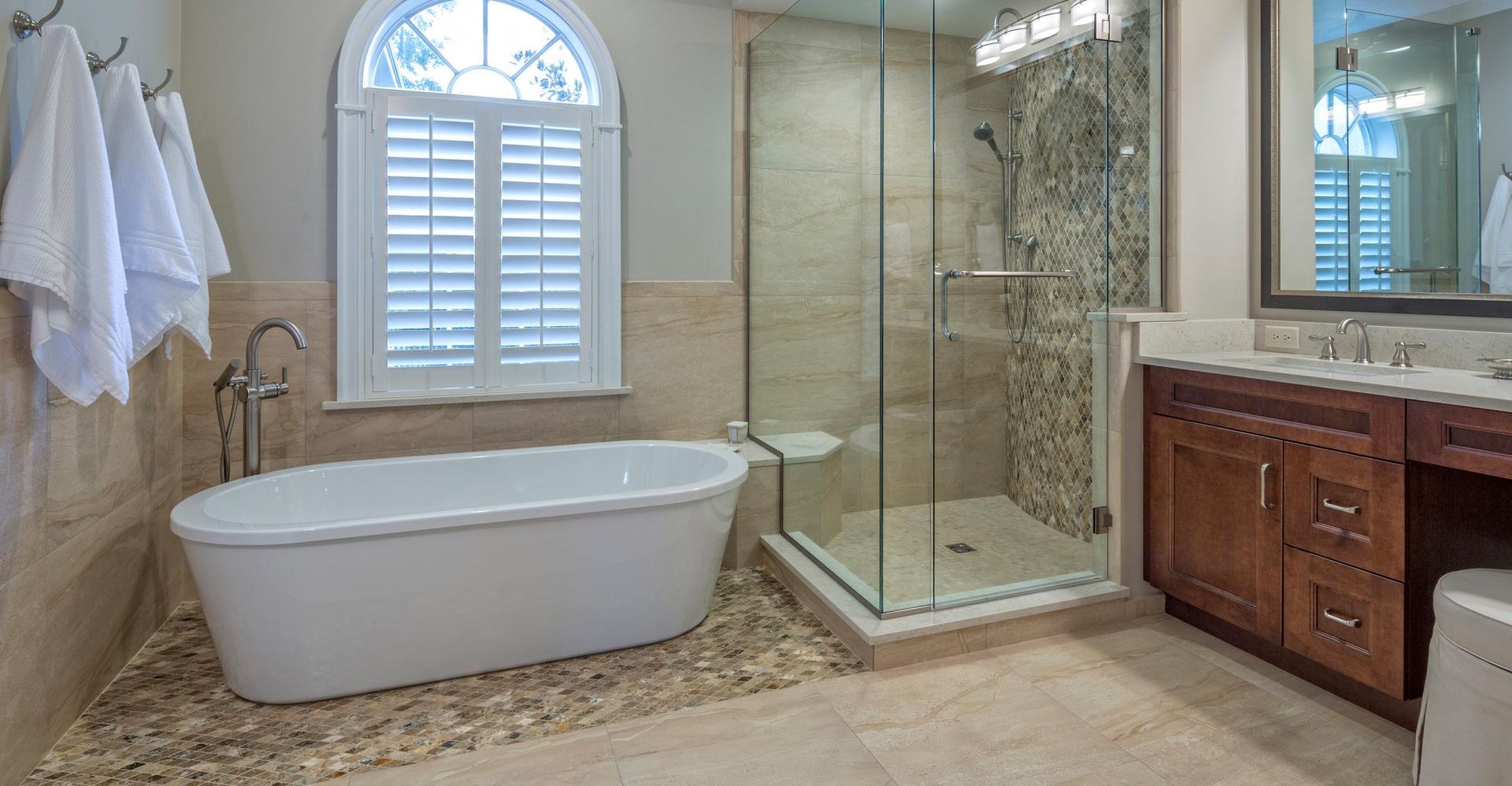 A bathroom with a tub and a walk in shower.