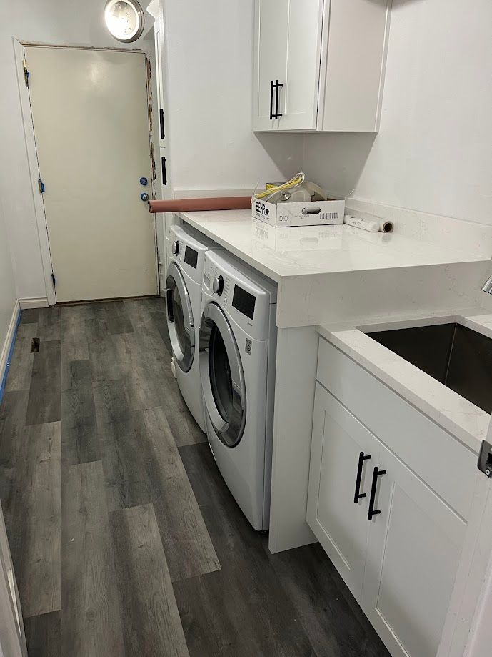 A laundry room with a washer and dryer and a sink.