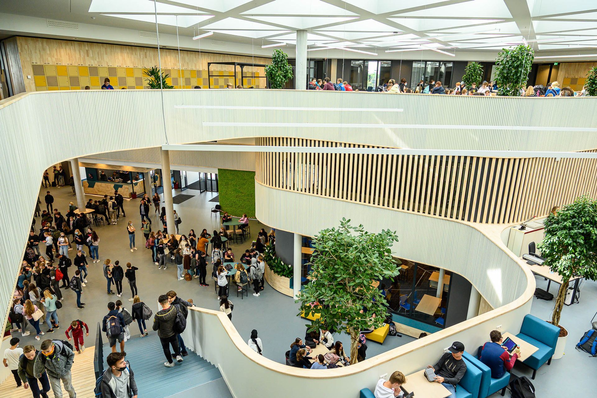 Een grote groep mensen loopt door een groot gebouw.