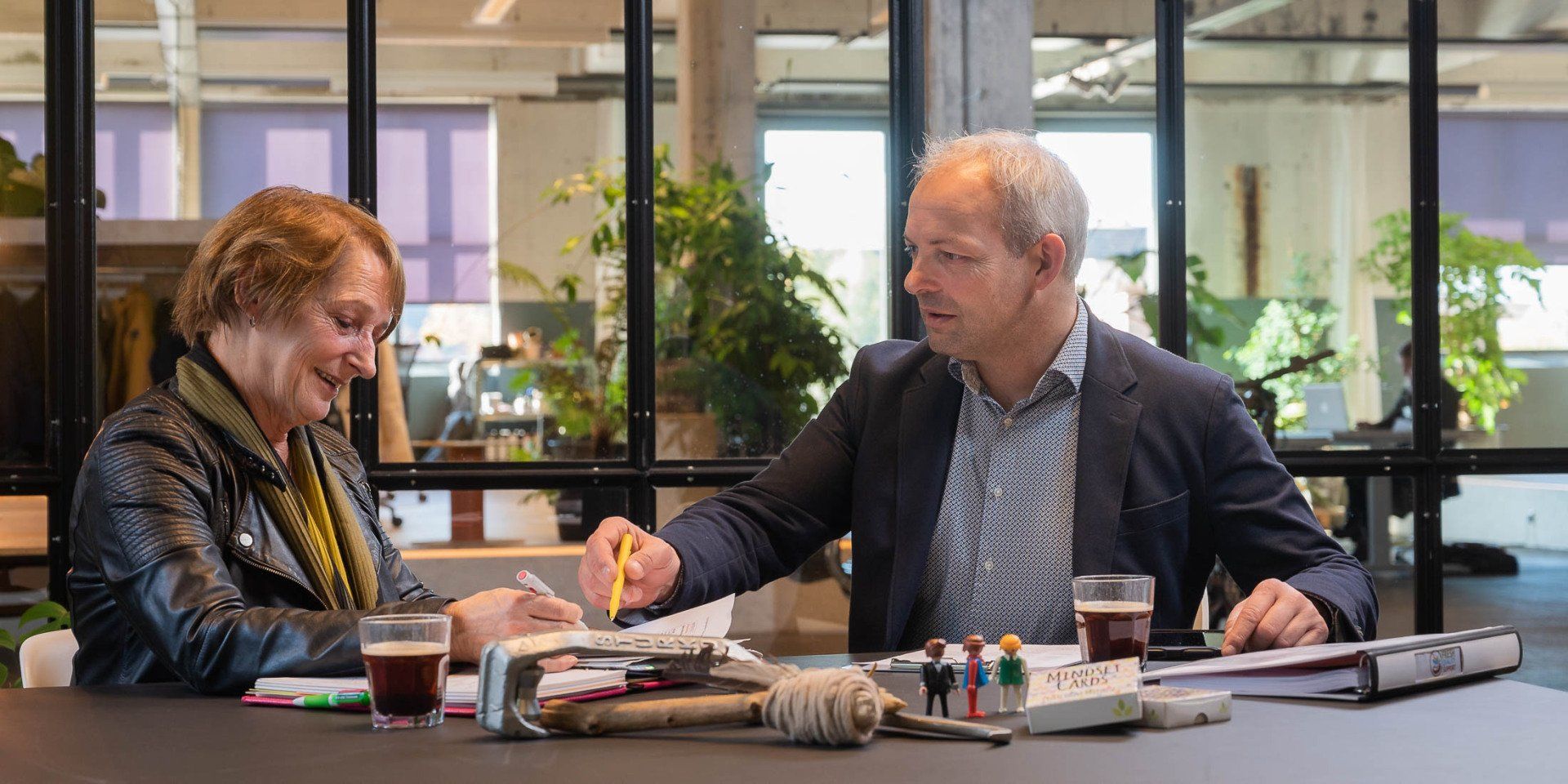 Een man en een vrouw zitten aan een tafel met elkaar te praten.