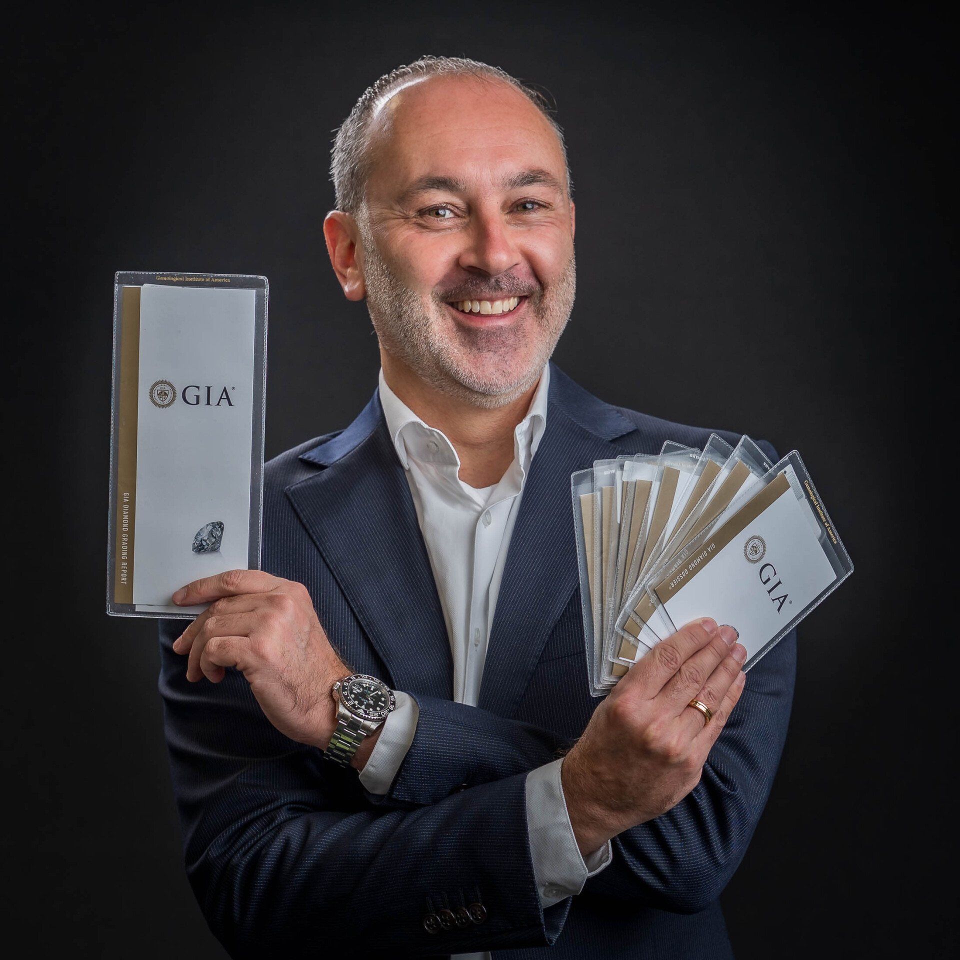 Een man in een pak houdt een boek vast waarop gia staat