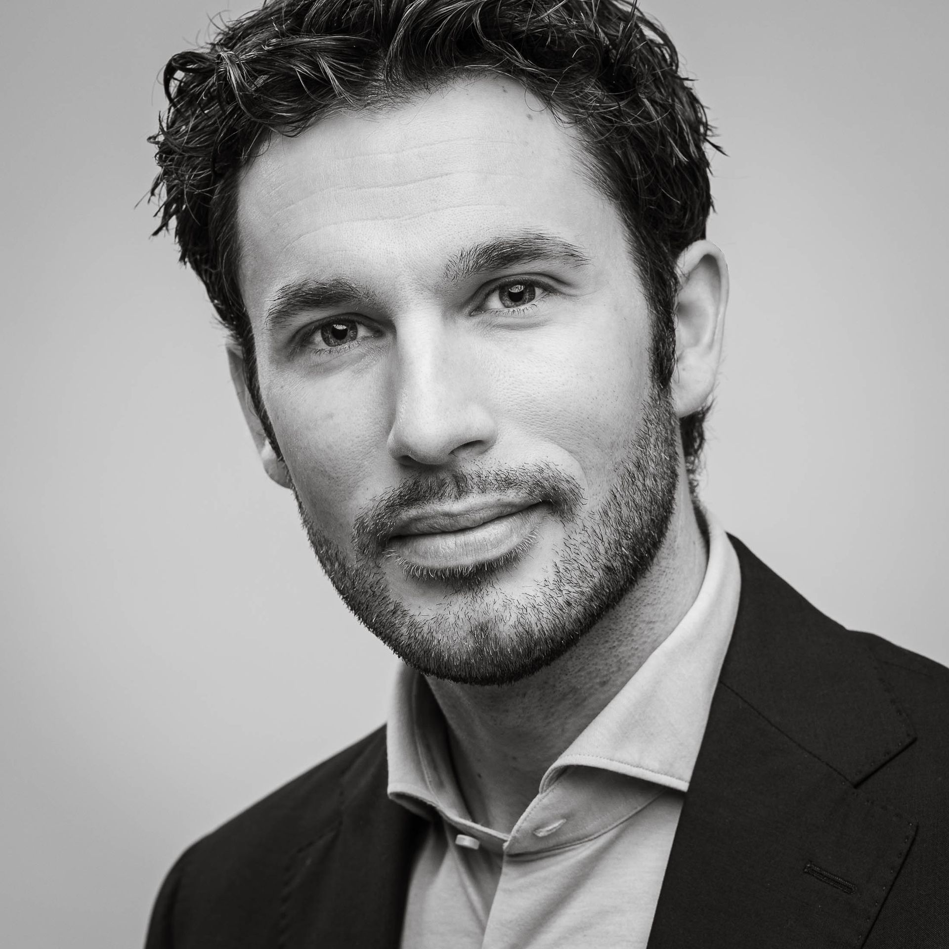 Een zwart-witfoto van een man in een pak