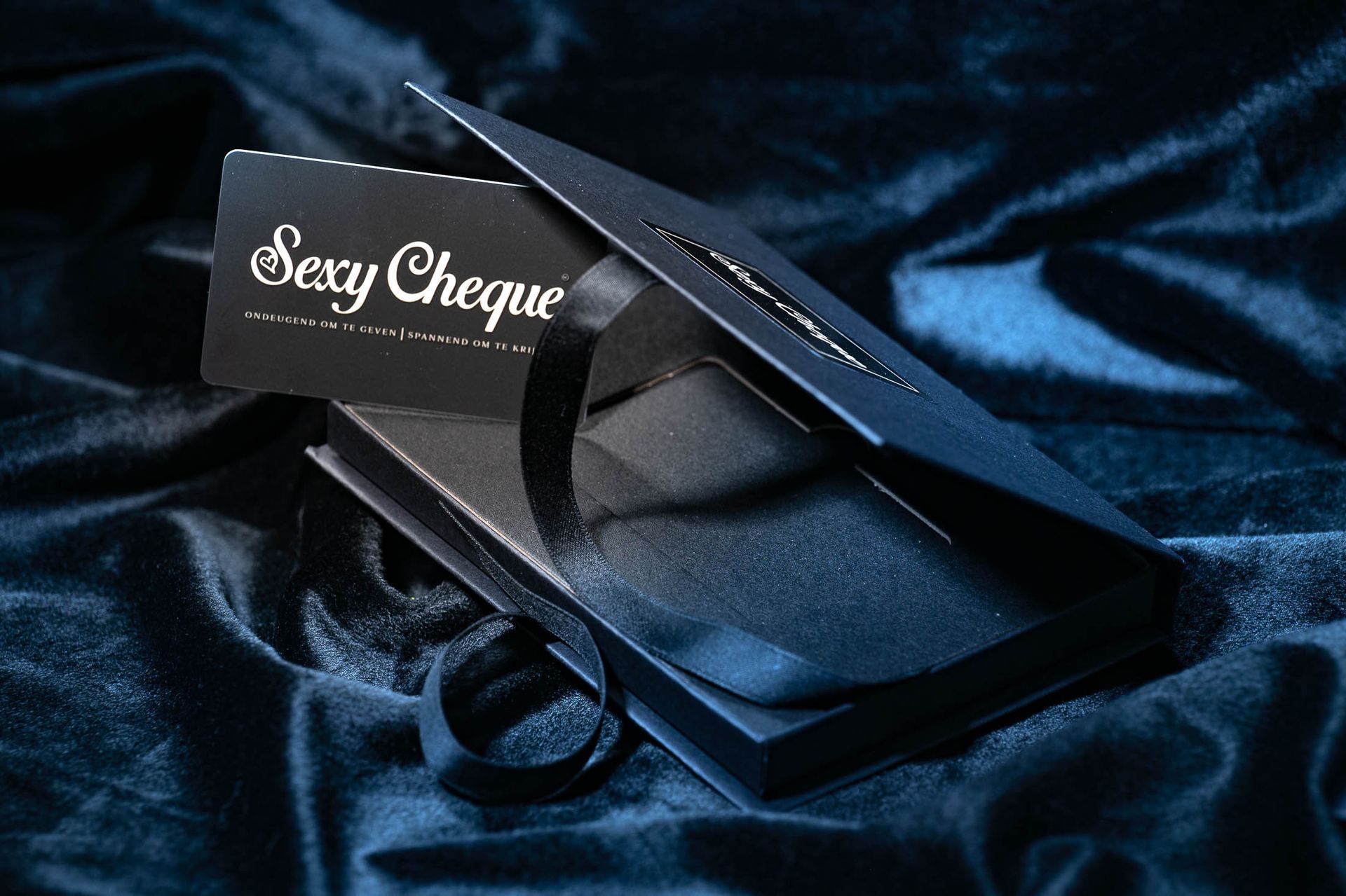 Een zwarte cadeaukaart met de tekst 'sexy cheque' erop