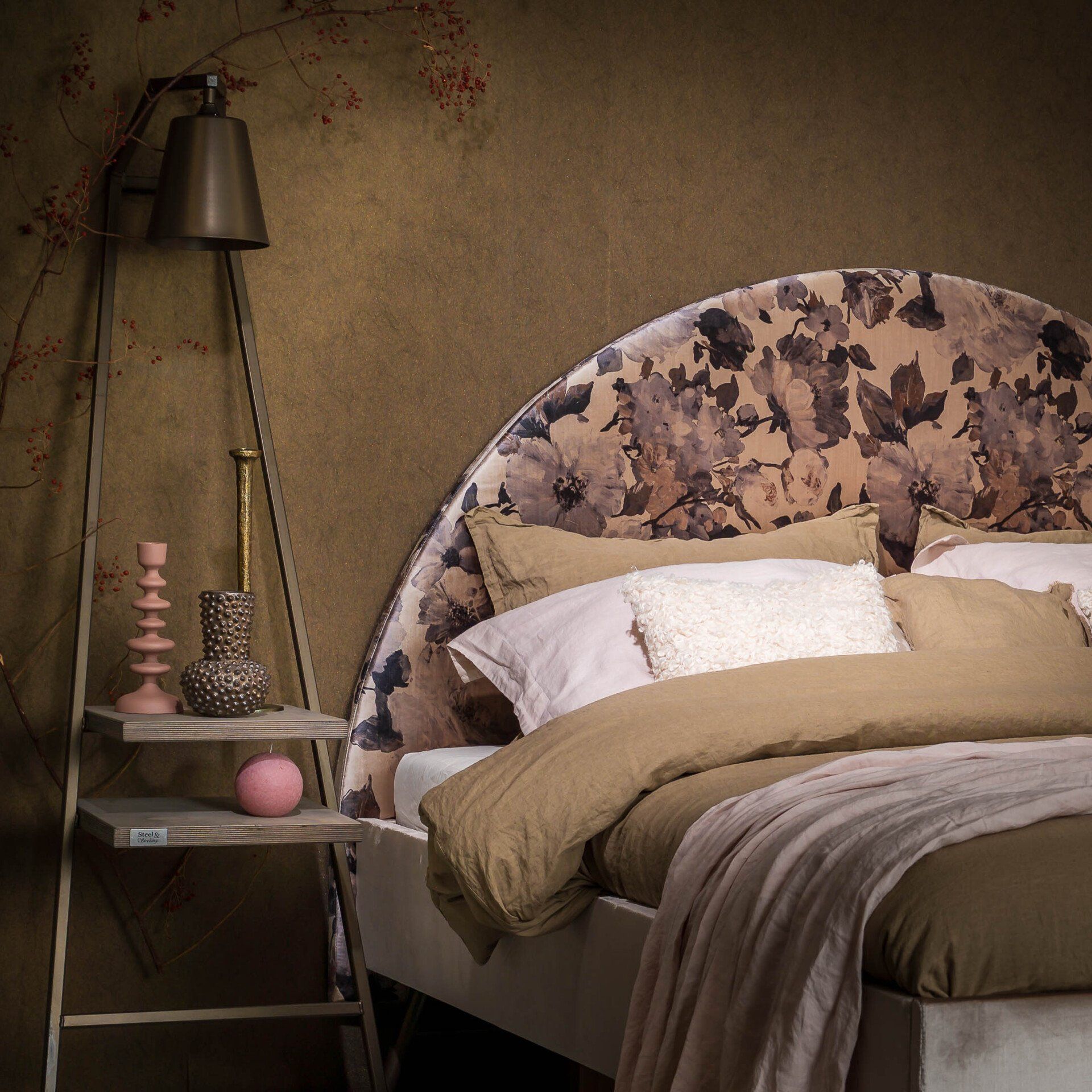 Een bed met een bloemenhoofdeinde in een slaapkamer