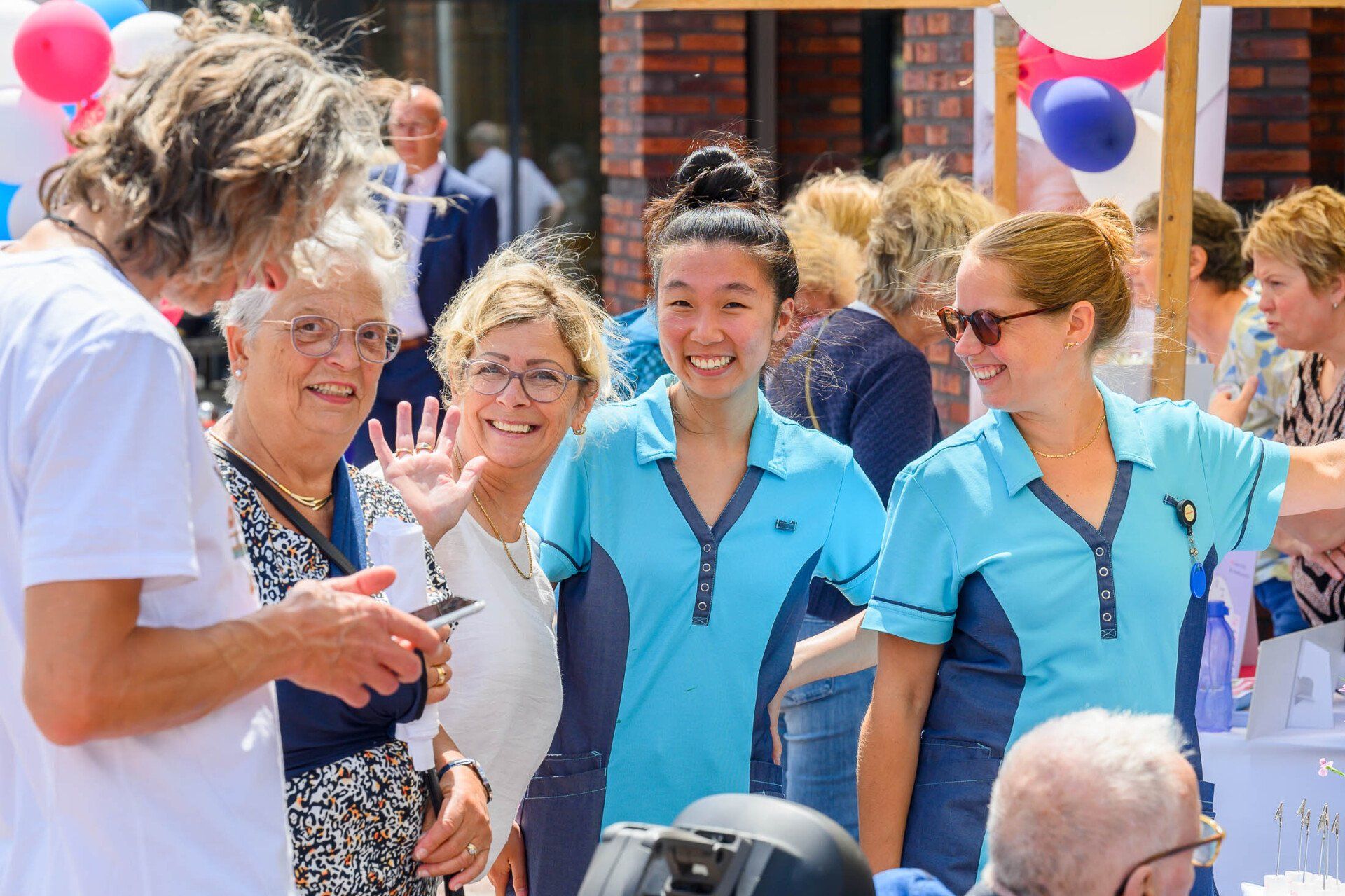 Een groep mensen poseert voor een foto voor ballonnen.